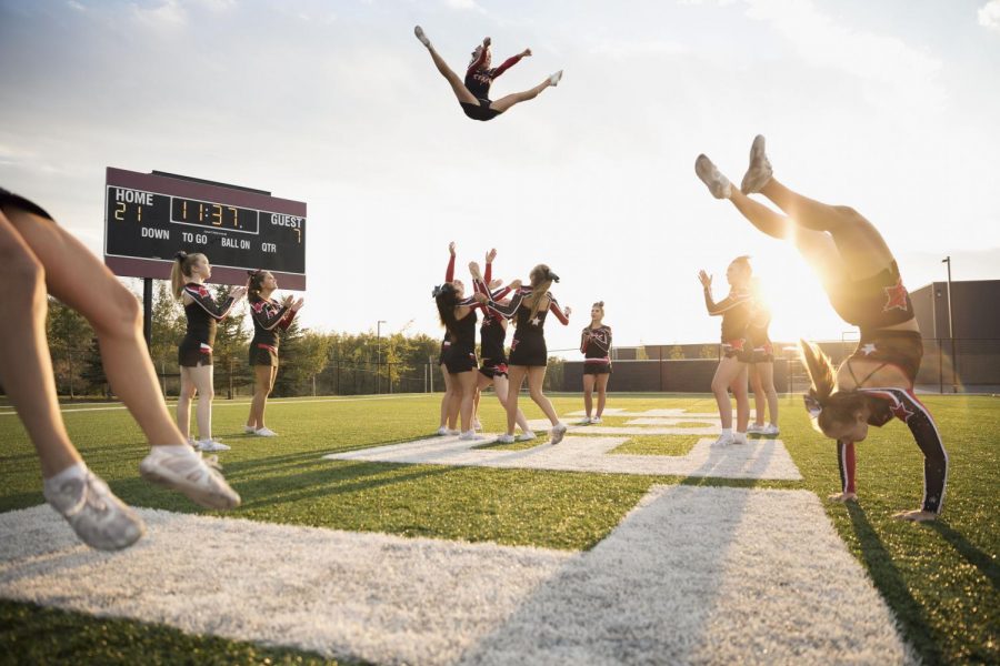 A cheer team jumps, tumbles, and stunts at a game. Graphic courtesy of ThoughtCo.