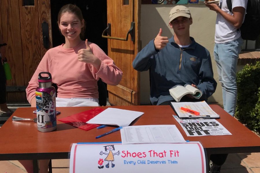 Bridgid Corbin (19), VWS Head of DSPs, and DSP Liam Gerken (20) remind students to donate to Shoes That Fit outside of the Hooper Center. 