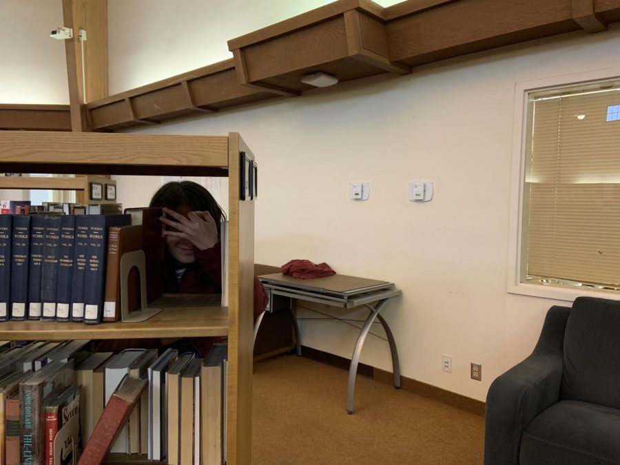 Can you find her? Ashley Munguia (‘21) hides from potential assassins in the Fawcett Library.