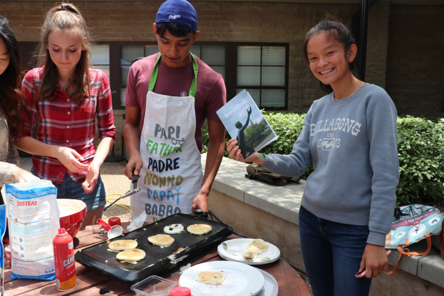 Patrick+D%C3%B3%C3%B1ez+%28%E2%80%9821%29+and+Amelie+Cook+%28%E2%80%9820%29+serve+pancakes+while+Carly+Granda+%28%E2%80%9821%29+enjoys+her+copy+of+Breakfast.