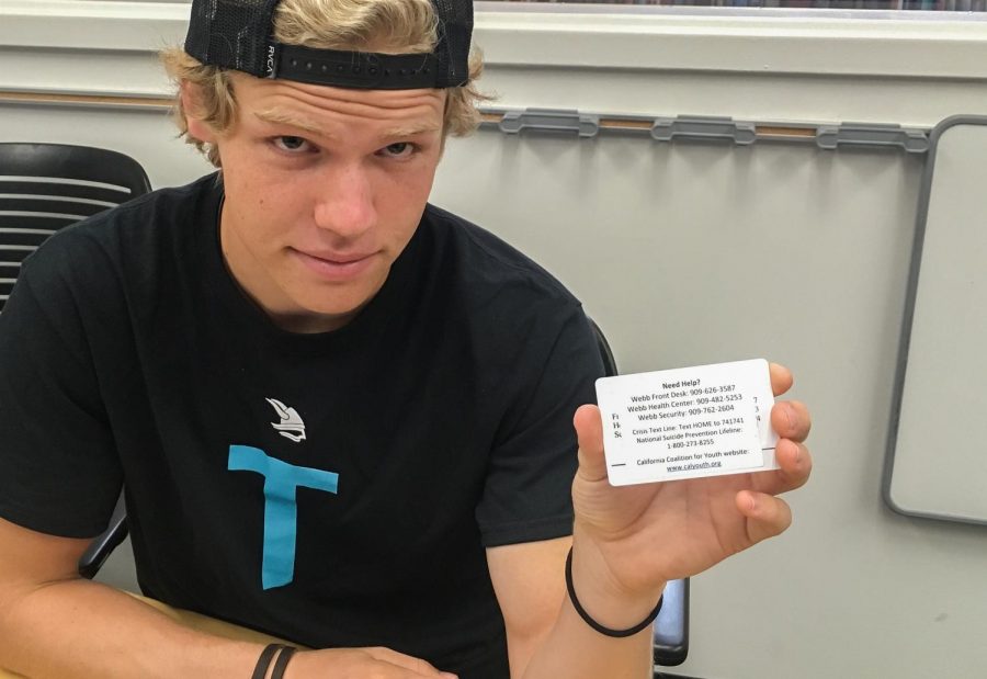 JD O’Donnell (‘20) holds up his student ID, displaying the new sticker with the number for the suicide hotline.