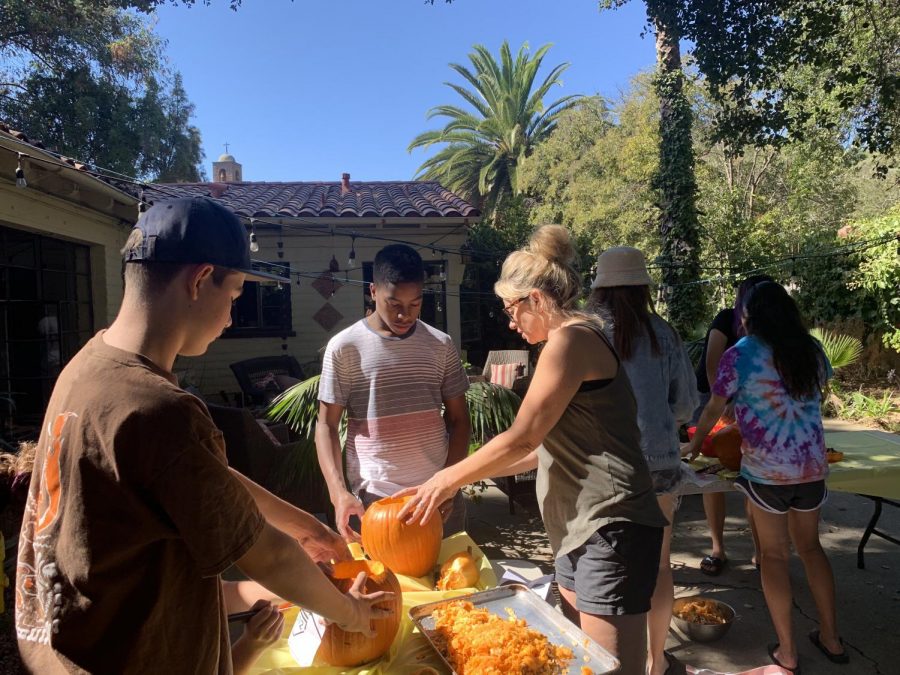 Romana Quick, ISP coordinator, helps Ochuru Ochuru (‘23) and Aidan Helgeson (‘23) with their pumpkins. 