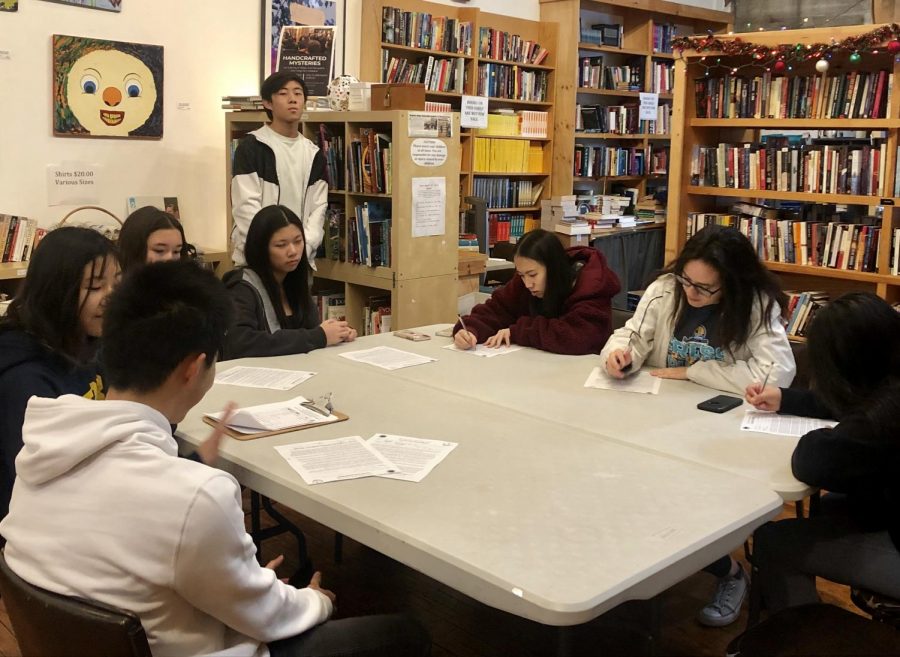 Webb students sit around the table to wrap books at the Claremont Forum.