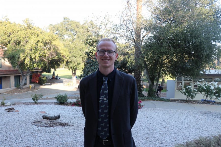 Kenneth Dennie smiles for the camera in front of the Humanities Office. 