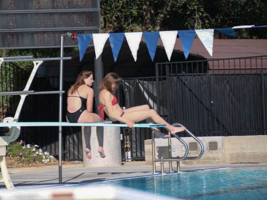 Livia Hughson (‘21) and Kennedy Becher (‘21) spend time on the diving board before swim practice. 