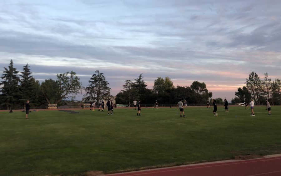 Webb Football participates in a socially distanced practice on Faculty Field. Players stand more than six feet apart with masks on.  