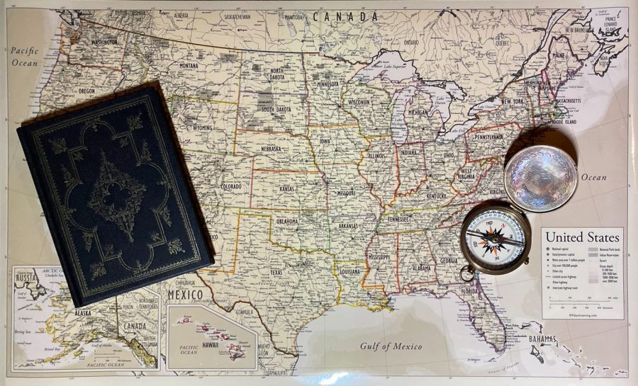 The map of the USA, propped with a worn compass and a leather book.  