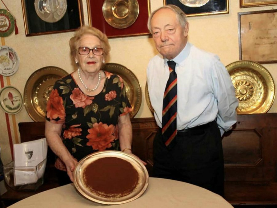 Co-creators Ado Campeol and Alba Di Pillo pose next to a bronze plate of Tiramisu. 
