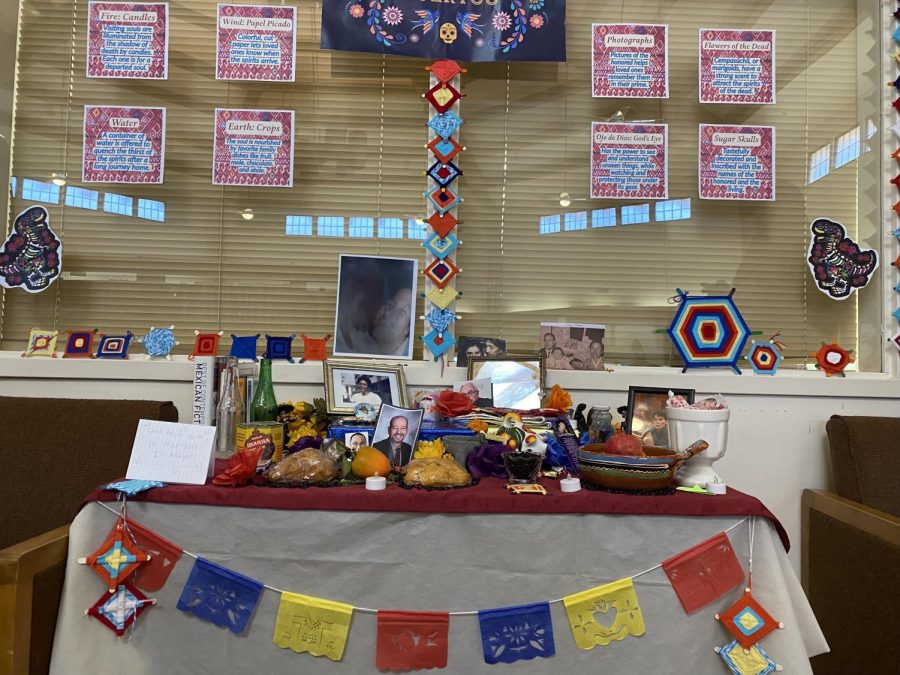 Community ofrenda, Spanish for altar, in the library set up by Sofia Centeno (‘22) and Emilia Bordage (‘23). Above the ofrenda are posters which you can read to learn more about each piece on the ofrenda. 