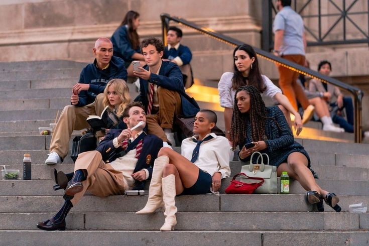 The cast of Gossip Girl sits on the steps of the MET.  