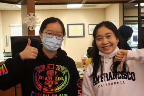 Sunny Yu (‘22) wears her mask in the library and gives a thumbs-up to the camera because she follows the appropriate COVID-19 protocols. On the other hand, Jenny Wang (‘24) violates Webb rules by unmasking indoors. She condemns these types of actions by giving a thumbs-down.  