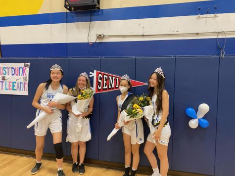 The team’s senior players, (pictured from left to right) Leeann Shu (‘22), Bianca Arteaga (‘22), Marie Blake (‘22), and Allison Paik (‘22), pose next to a banner following the incredibly close, yet gratifying game. They are wearing crowns and sashes, and holding bouquets that were given to them by their team members.  