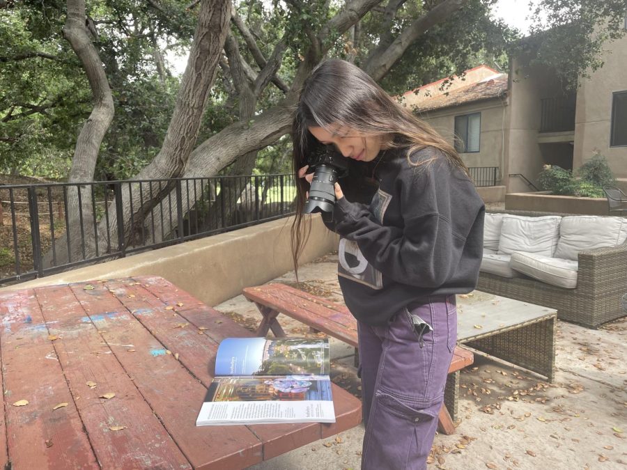 : Jamine Wan (‘23) snaps a photo of the magazine spread which features her own contest-winning photo.  