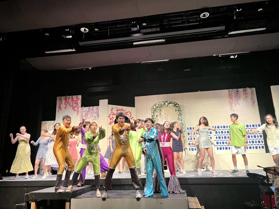 The musical Mamma Mia ends with “Waterloo.” The eight main characters —Harry Bright, played by Ray Kan (‘24), Bill Anderson, played by Stratton Rebish (‘24), Sophie Sheridan, played by Kiera Yap (‘22), Sky Ramand, played by Jonathan Lou (‘22), Donna Sheridan, played by Eunice Lau (‘23), Sam Carmichael, played by Gerry Song (‘22), Tanya Chesham-Leigh, played by Mia Baldwin (‘22), and Rosie Mulligan, played by Sofia Centeno (‘22) — lead the audience in clapping and dancing while dressed in bright colorful costumes. 