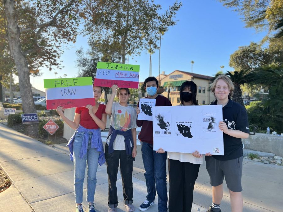 (Left to Right) Annalise Centeno (‘26), Amelia Centeno (‘26), Marc Zambrano (‘26), Heidi Lau (‘26), and Rowan Stamires (‘26) hold signs at the crossroads of Indian Hill and Foothill Boulevard in Claremont. Some of the protest signs read “Free Iran,” “#MahsaAmini,” and “Justice for Mahsa Amini,” messages the student protesters hoped to communicate at their public demonstration. “Honestly, I never expected people to support and care this much,” said Mandana Mojaverian (‘26), whose family helped organized the protest. “But it also makes me question why they didn’t before, because this has been happening for so long.”  