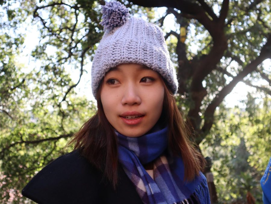 Jasmine Wan (‘23) bundles up with a purple, knit beanie and a plaid, blue scarf. Her accessories accent her fluffy, black jacket and flared denim jeans.