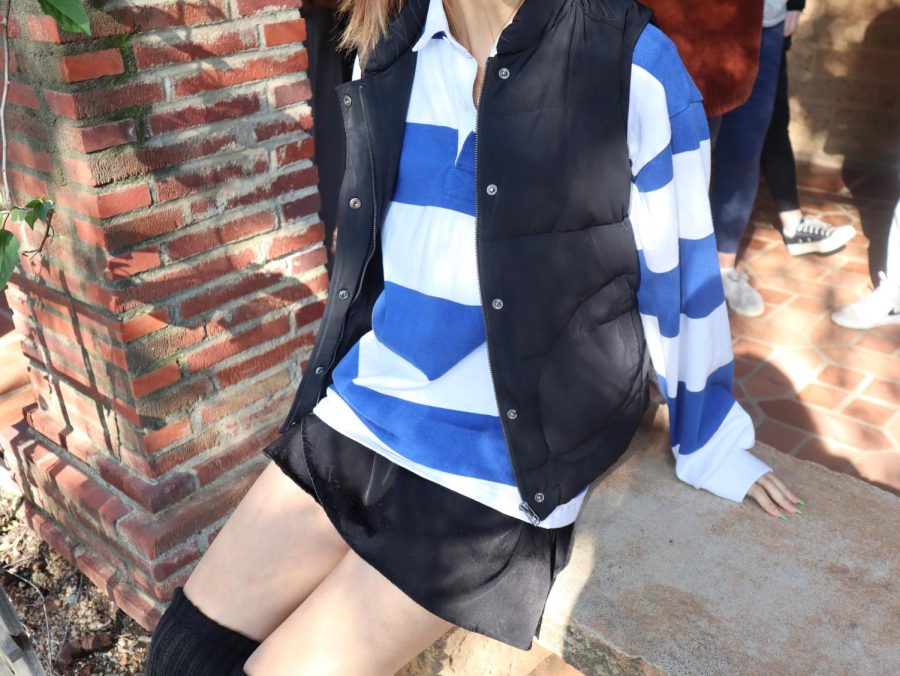 Wendy+Chang+%28%E2%80%9823%29+poses+with+a+puffer+vest+and+striped+long-sleeve+shirt.+She+pairs+these+tops+with+a+black+skirt+and+matching+black+leg+warmers.+