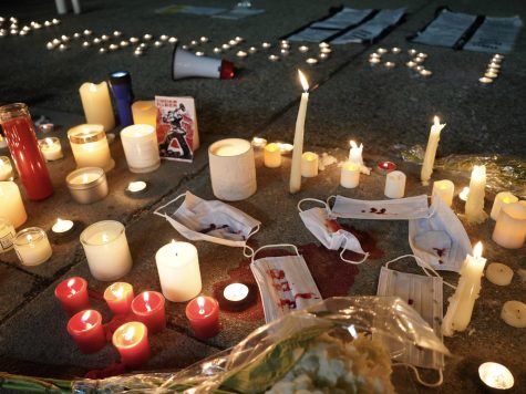 Candles, flowers, and masks drenched in red paint were placed at the vigil in front of the Chinese Consulate General in Los Angeles on November 27th, 2022. An old propaganda from the Cultural Revolution saying “smash the old world, build the new world” (打碎旧世界，创立新世界) was reclaimed as a statement against the government. These objects symbolized resistance against zero covid policies and the violence brought by the CCP. 