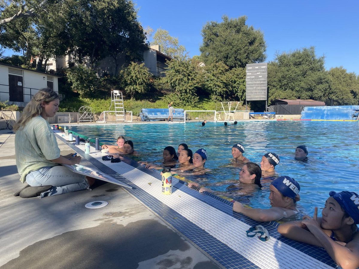 Warmed up for practice, the VWS Water polo team all swim to the edge of the pool to listen to their Head Coach Sawyer Belville about what drills they have planned for practice. This is Coach B’s second year coaching VWS Water polo, and she is very excited for the new year, planning to beat their record of 6-15 overall last year. Having recently taken WSC Water polo to win the Valle Vista league for CIF with a 15-0 league record, Coach is ready to lead the team to a successful season.  