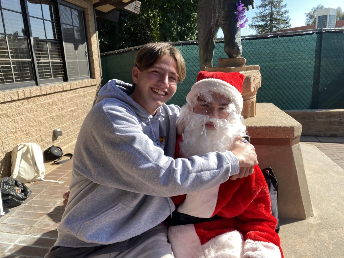 Ethan Norman (‘25) sits on Santa Claus’s lap, smiling with holiday cheer. As his personal assistant, he takes Santa around campus to reward hardworking Webbies with gifts and ask what students want for the holiday season before the campus leaves for break. 