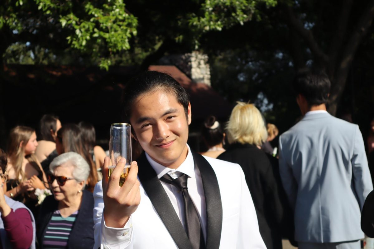 Hanbo Xu (25), in his formal attire, enjoys a glass of apple cider, one of the many refreshments available during the pre-prom reception in front of the Alf Museum. “The cider was extremely extravagant, lavish, and rich, while the food looked very appetizing,” Hanbo said. “Holding these delicate cups made me feel like Gatsby. The toppings on the cupcakes glistened in the sun, as mouthwatering flavors invited a tsunami of joy in my brain.” 