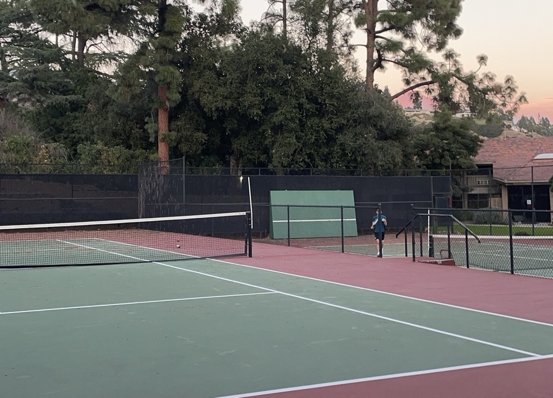 It is 4:55 PM.  Webb’s two upper tennis courts nestled in between the Jameson, Kirkhill, and Appleby dorms, glowing beneath an October sky washed in crimson. Soon, darkness will settle, and with daylight savings pushing sunset an hour earlier, dwindling light will make it tough for the players to carry on. “A few small lights would a nice addition,” said Larry (‘26).  