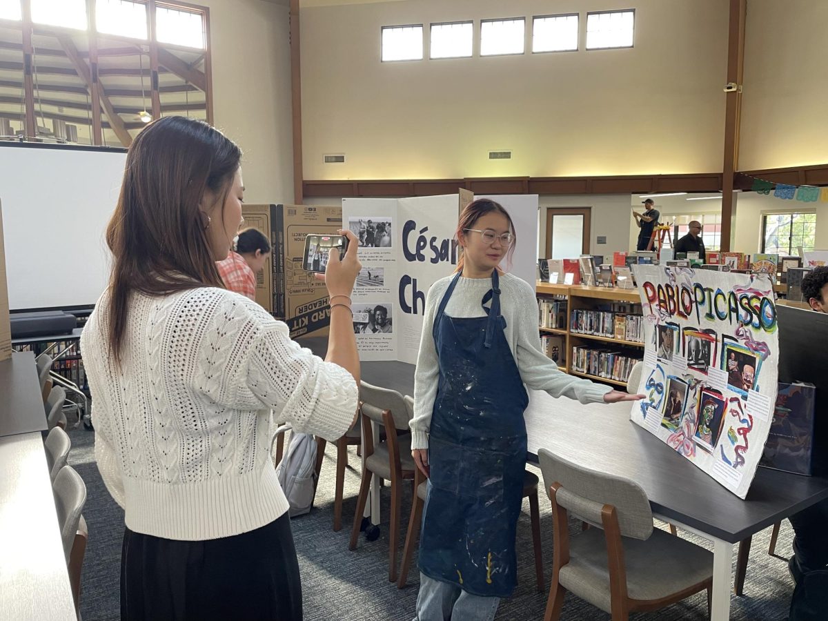 Natalie Au (‘26) portraying Pablo Picasso gives her presentation about Picasso’s life and achievements while Anna Park (‘26) records her as part of the project. Other students performing at the central tables in the library speak as their Spanish-speaking figures as well. “I had the most creative freedom during this project out of all my years [of Spanish] and [got] to bring in my passions from outside of Spanish class,” Natalie said. The project was an intriguing scene for anyone who saw students in their costumes; what happens behind the scenes?