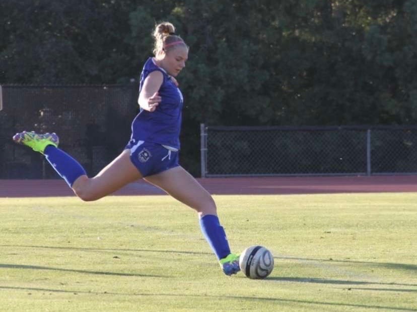 Standing tall, ready to strike is Kaitlyn Metz (‘25), a 4-year starting center back for the girls’ varsity soccer team. Focused, she prepares to take a free kick with the hopes of scoring or assisting a goal to help her team excel past their opponent. “My job isn't always defending,” Kaitlyn said. “A lot of times I find myself having to be an attacker, tapping into my other strengths as a player.” This moment captures Kaitlyn's motivation and effort as a two-way player: having the ability to be strong not only on the back line of defense but also as a key figure in the team's attacking system.  